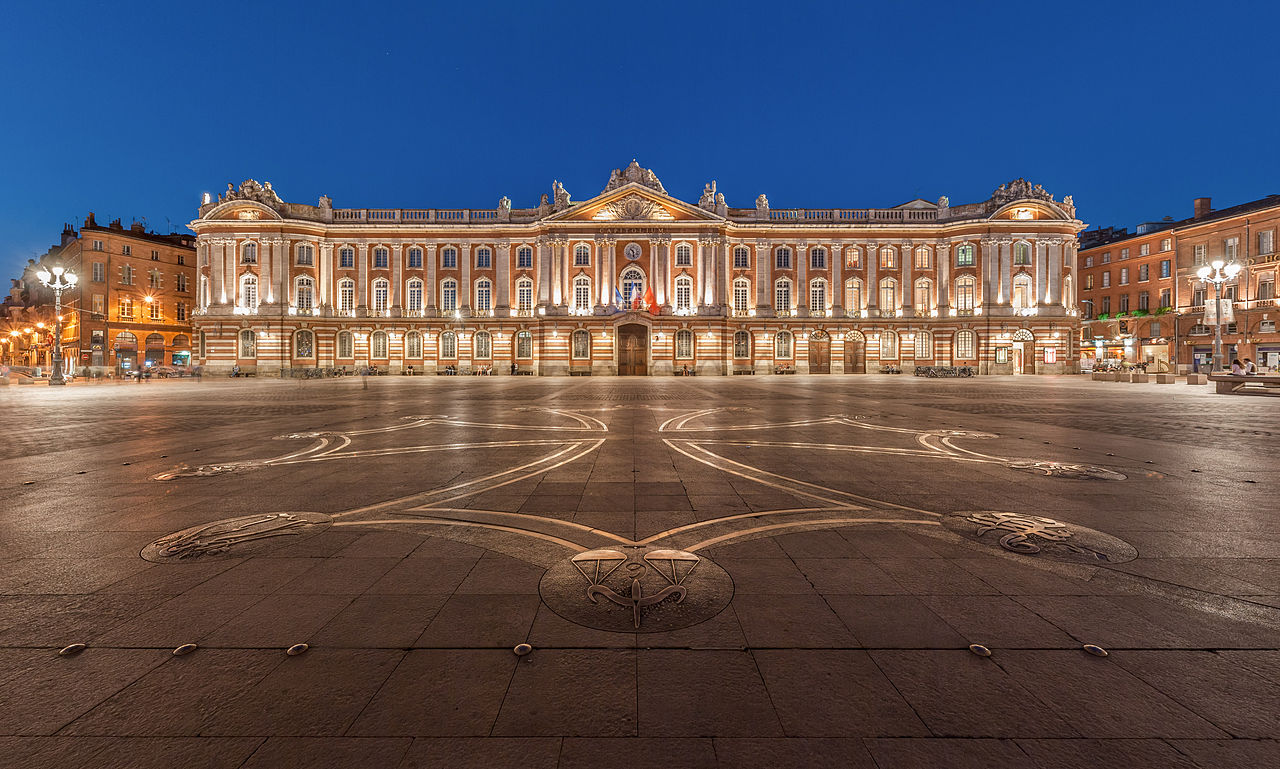 La place du Capitole à Toulouse, à la tombée de la nuit avec, au sol, la croix occitane dessinée par Raymond Moretti. Benh LIEU SONG, CC-BY-SA